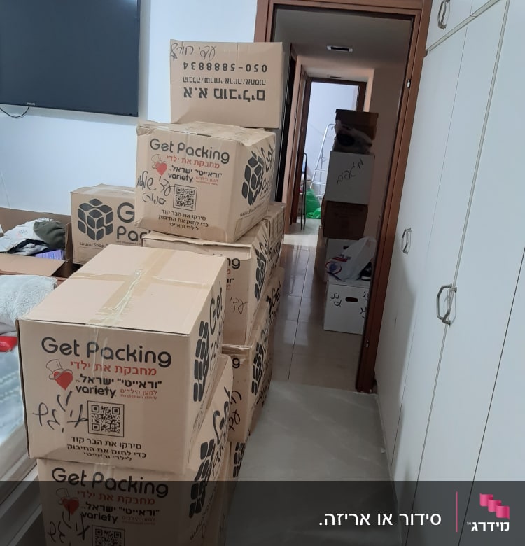 קופסאות קרטון מסודרות במסדרון הבית